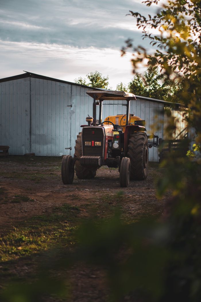 about-05 A tractor parked near a shed on a farm in El Carmen, Ñuble, Chile, showcasing rural life.